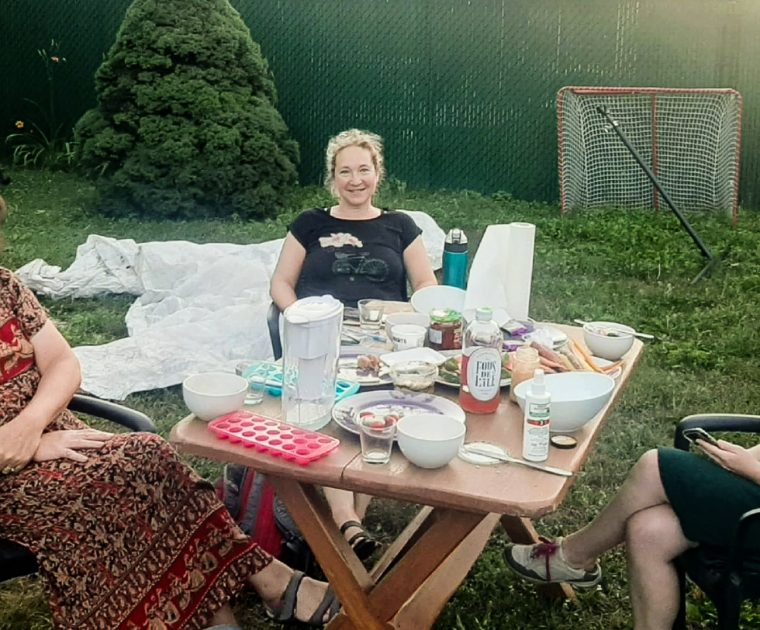 Trois citoyennes membres du comité citoyen pour la mobilité à BC sont assises dans un jardin en train de travailler